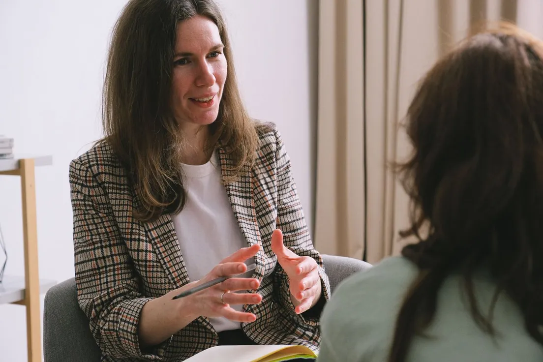 A therapist smiling warmly while talking with a client during a session